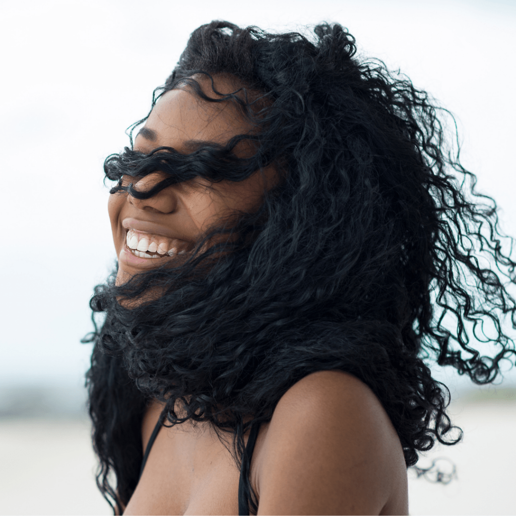 girl laughing while her hair blows in the wind