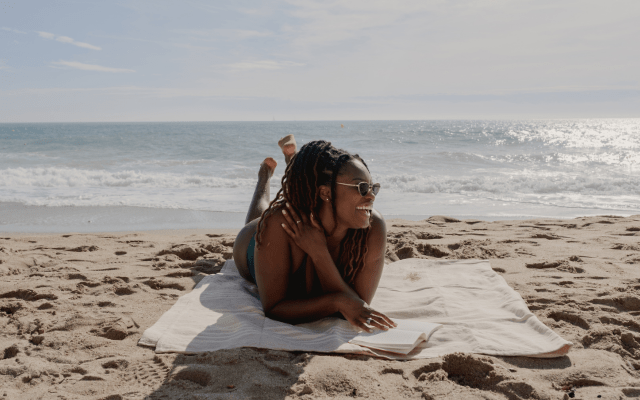 smiling black woman sunbathing at the beach