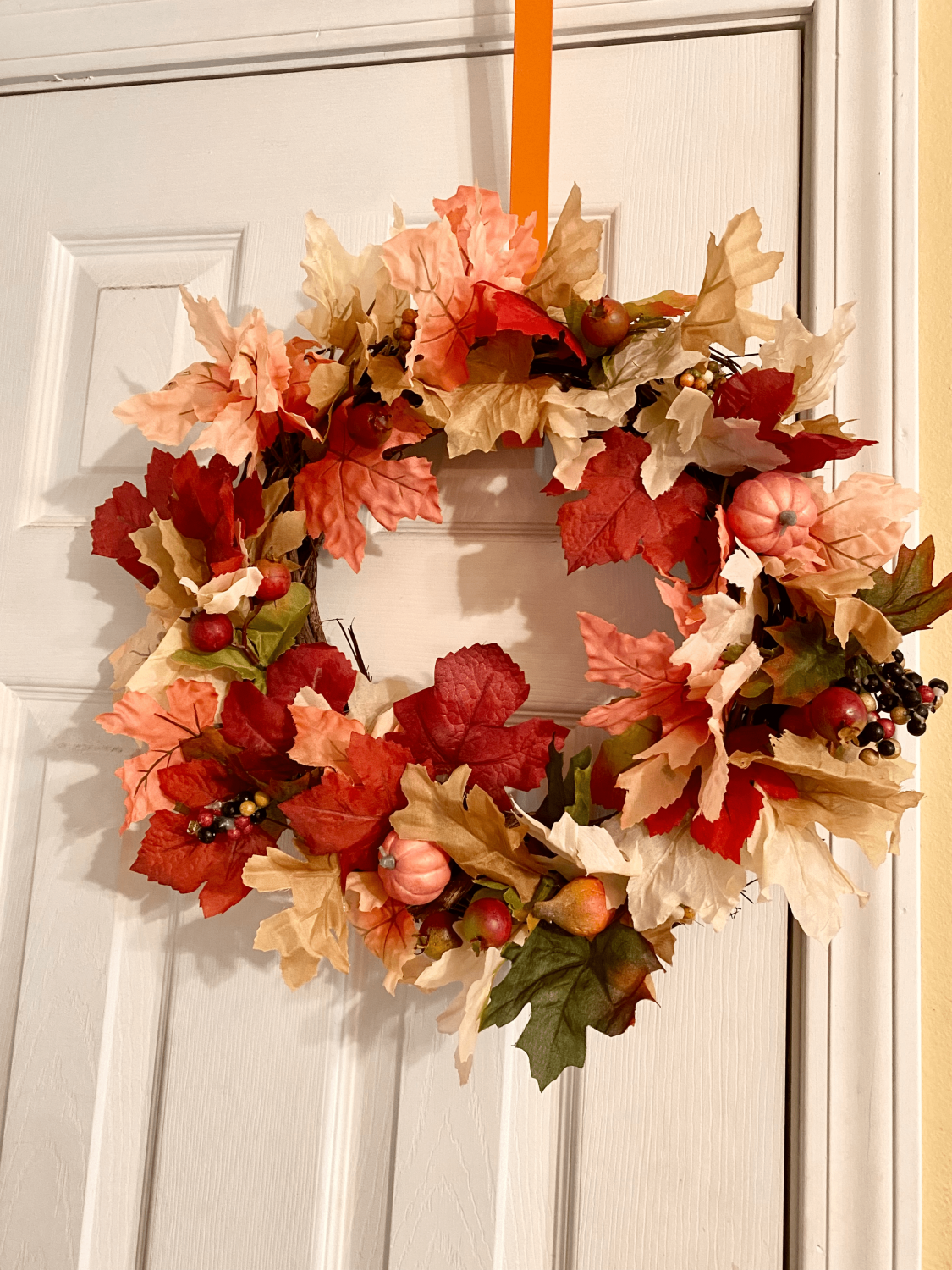 colorful fall wreath hanging on door 
