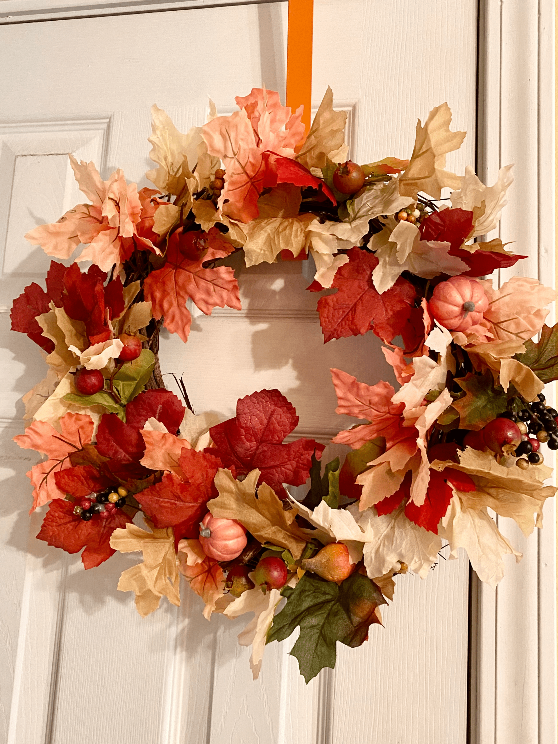 colorful fall wreath hanging on door
