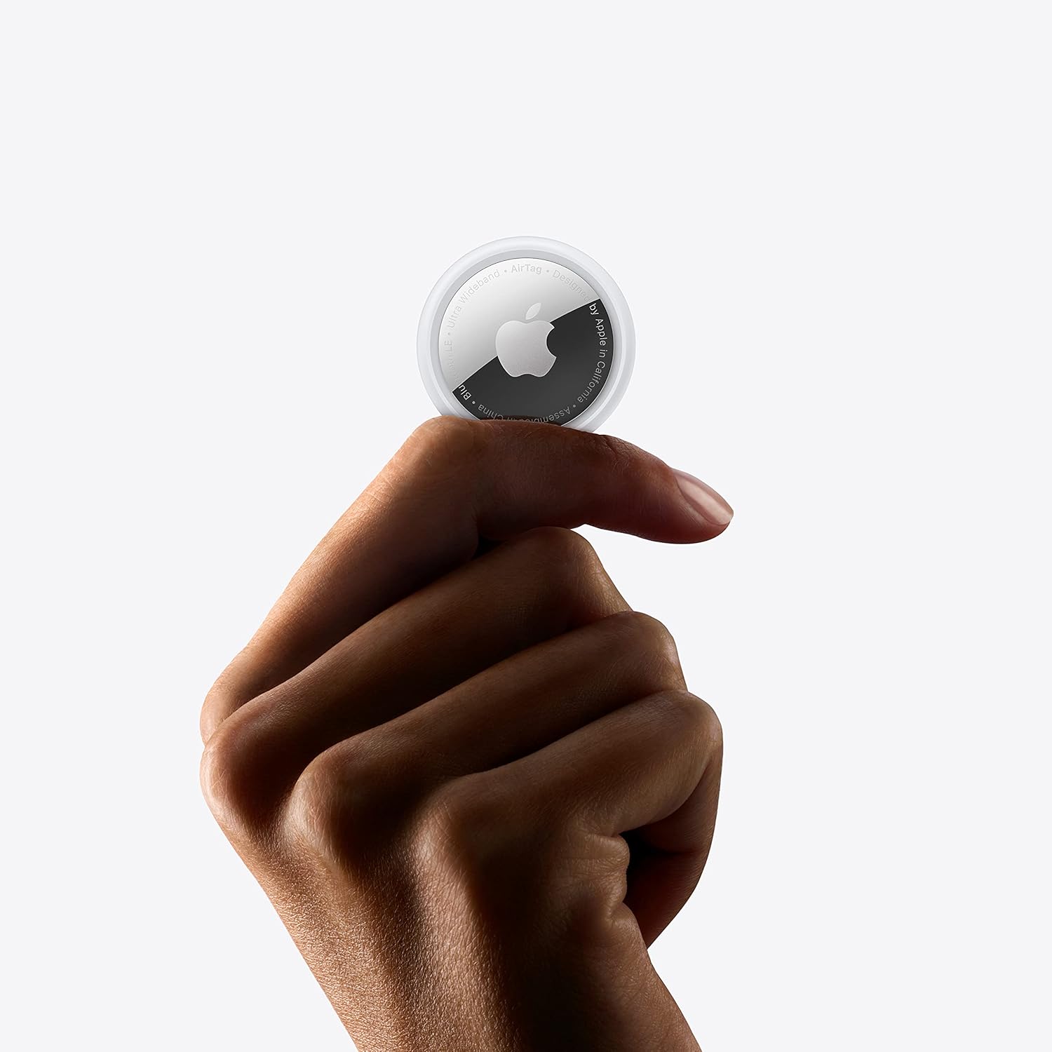 hand holding an Apple AirTag