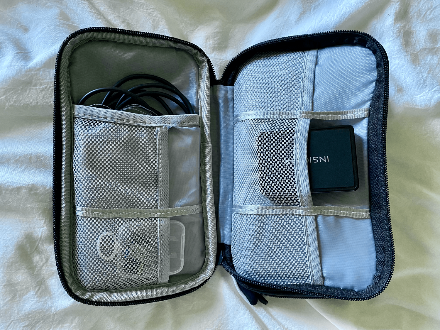 black tech organizer case with cables and chargers inside